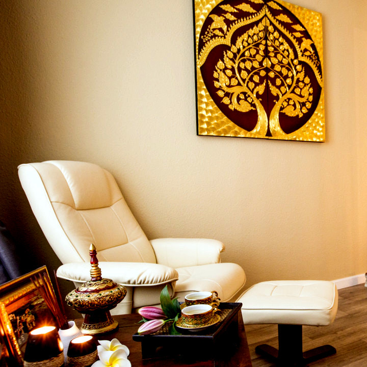 Ruhe-Sessel mit Bodhi-Baum-Bild und Tablett mit thailändischen Teegefäßen