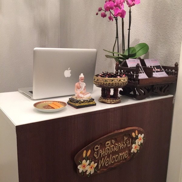 Empfangstresen mit Orchideen, Buddha-Figur und Willkommensschild